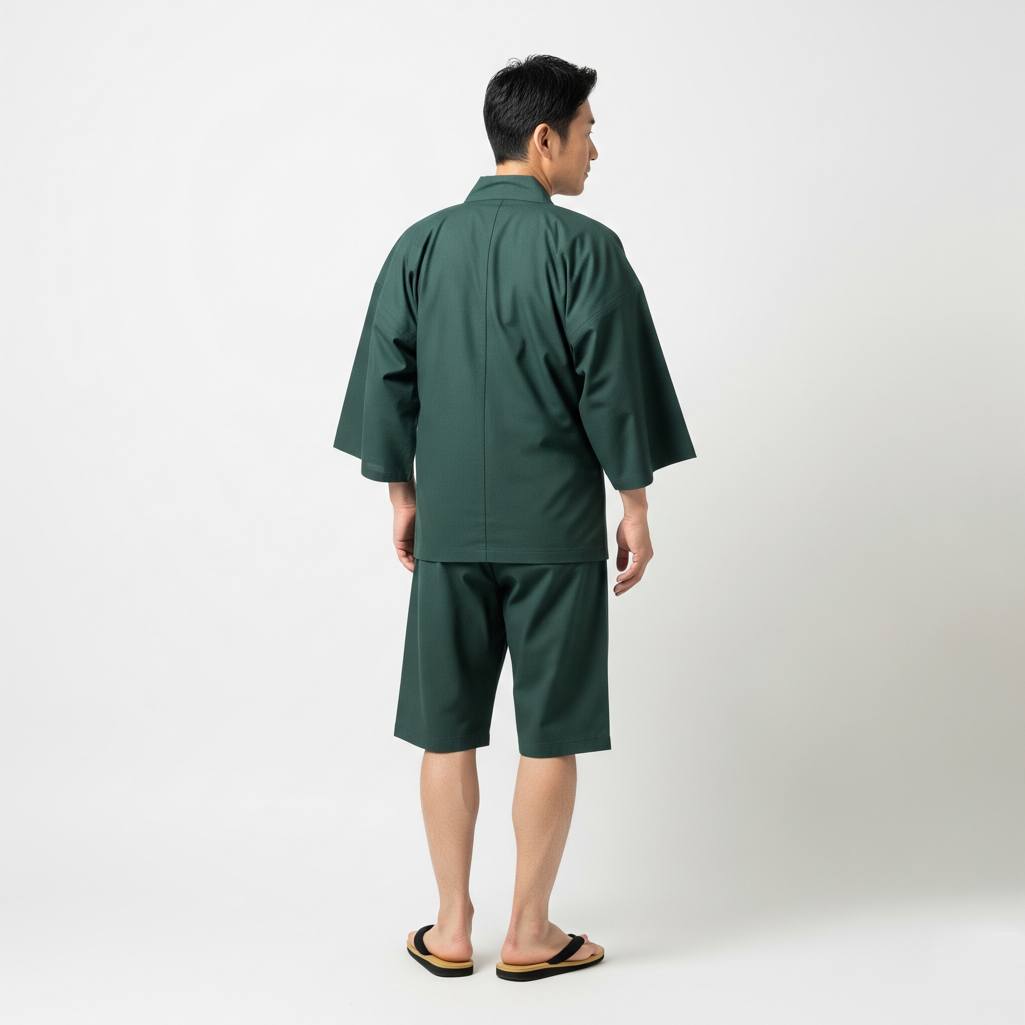 緑の甚平を着て後ろを向いている男性